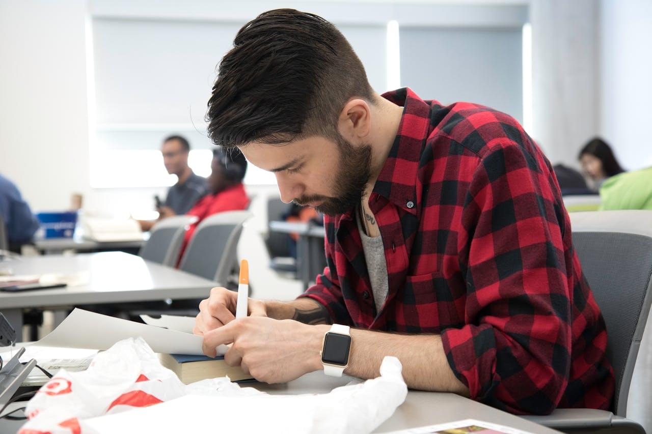 Студент конспектирует важную лекцию в блокнот